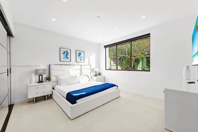 a bedroom with a bed and a large window