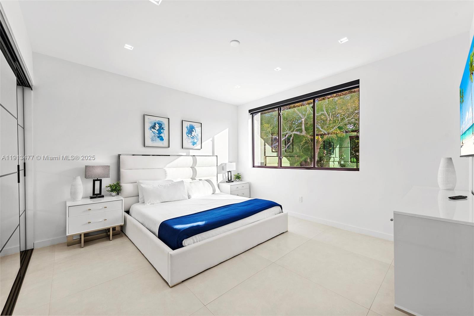 2572 Northeast 182nd Terrace North Miami Beach, FL 33160 - Photo 21 of 42 a bedroom with a bed lamp and a large window