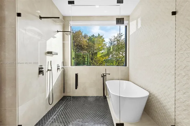 a bathroom with a tub a sink and a large mirror