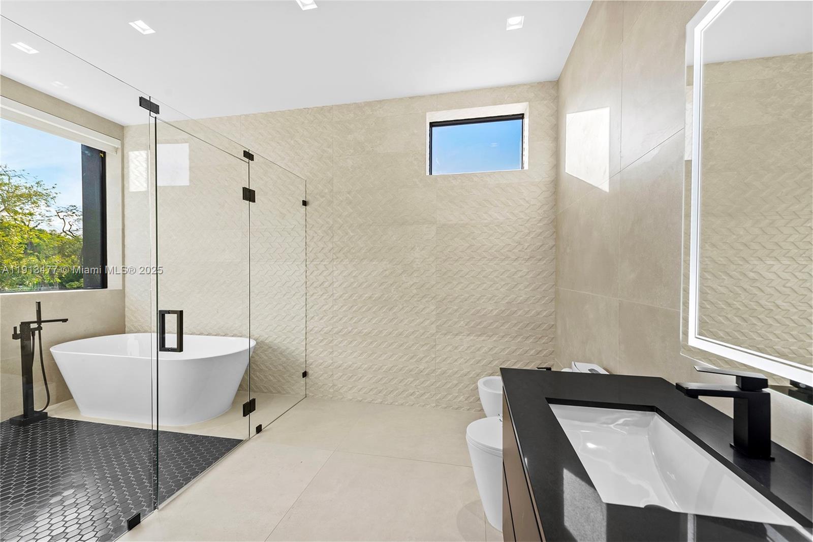 2572 Northeast 182nd Terrace North Miami Beach, FL 33160 - Photo 28 of 42 a bathroom with a tub a sink and a large mirror