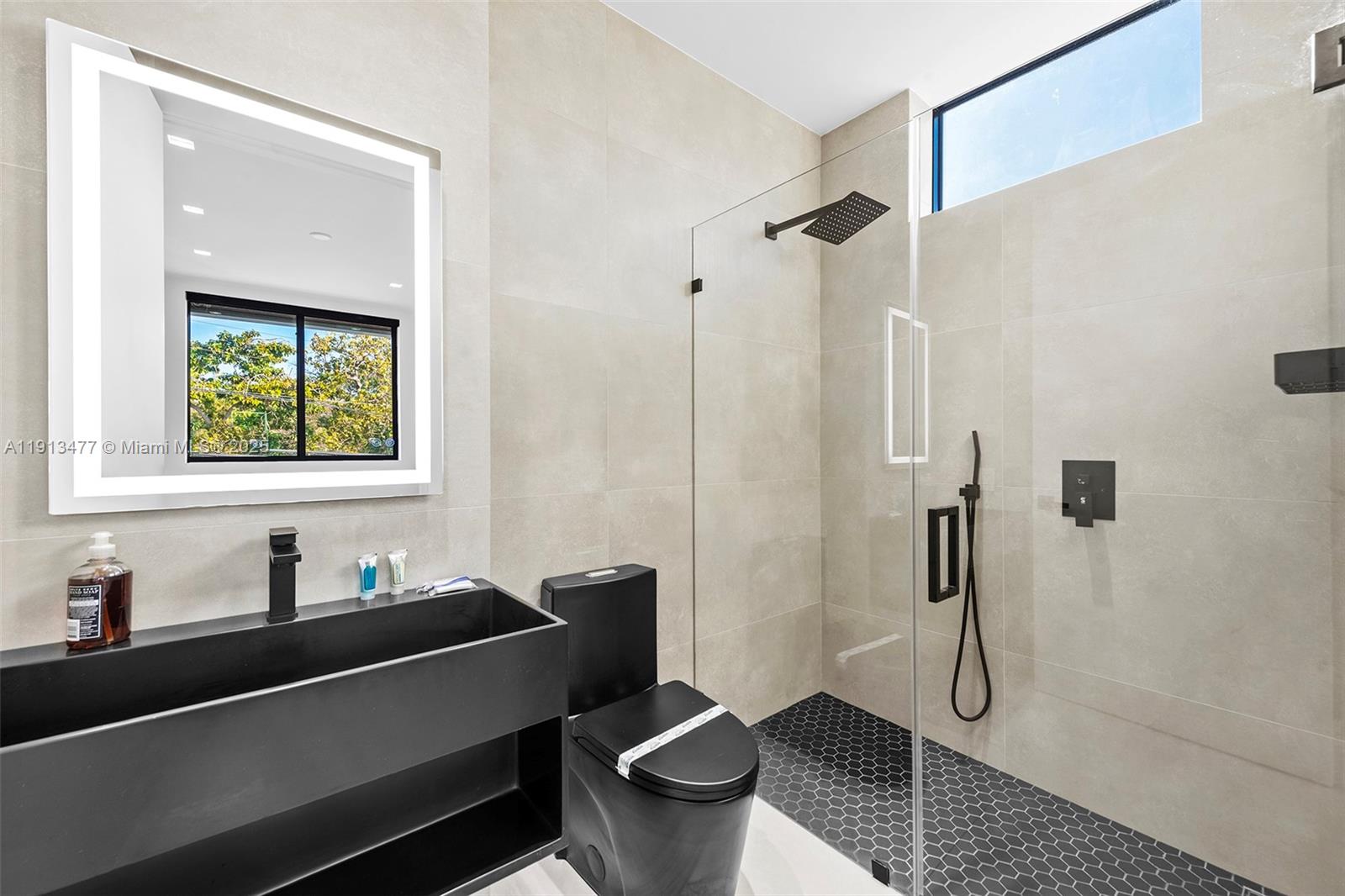 2572 Northeast 182nd Terrace North Miami Beach, FL 33160 - Photo 31 of 42 a bathroom with a sink a toilet and shower