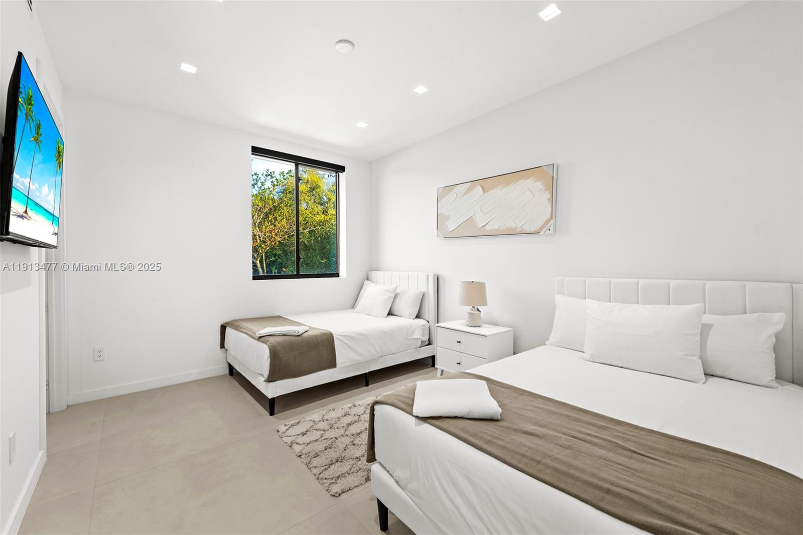 2572 Northeast 182nd Terrace North Miami Beach, FL 33160 - Photo 36 of 42 a bedroom with furniture and a flat screen tv