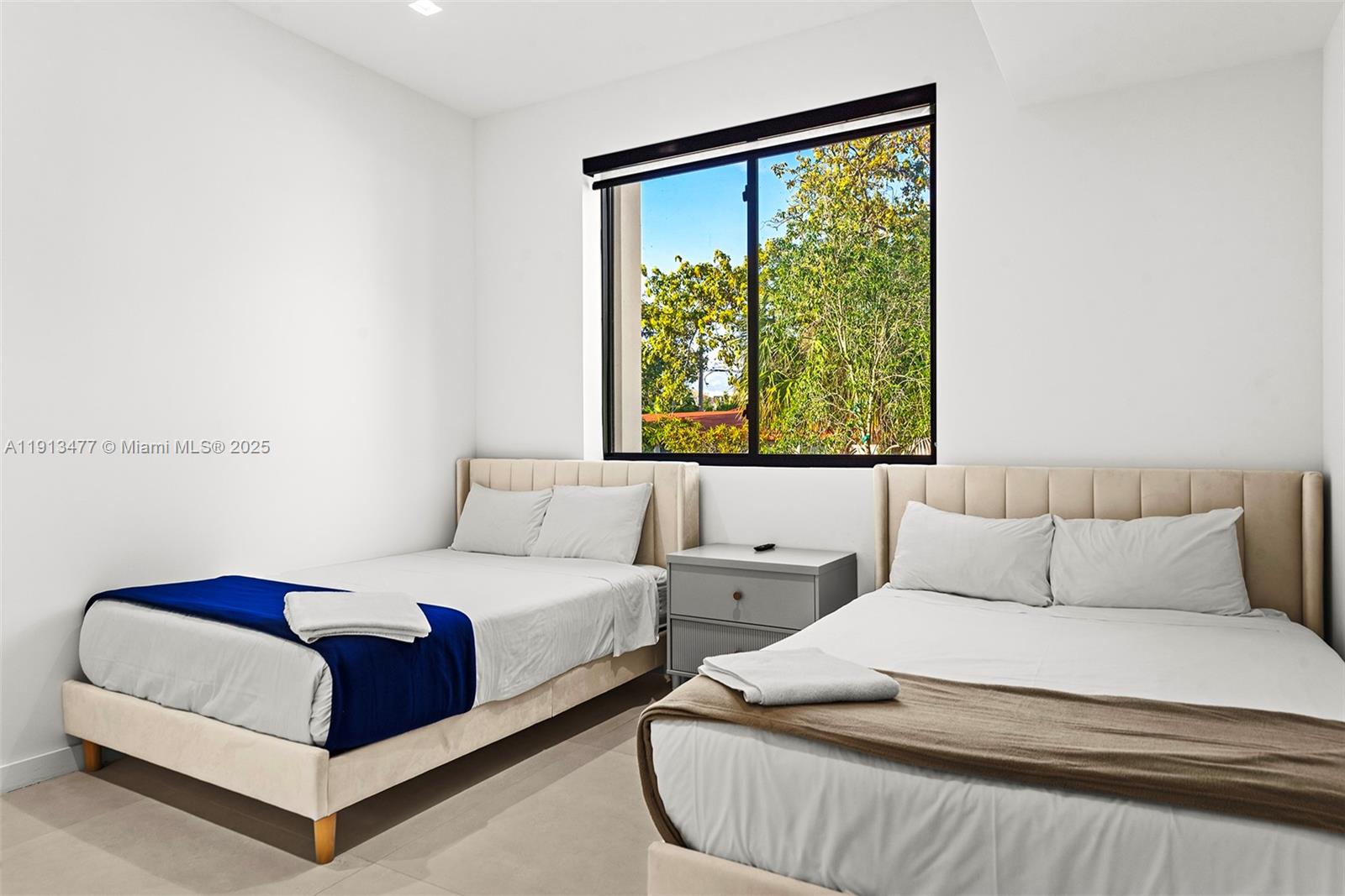 2572 Northeast 182nd Terrace North Miami Beach, FL 33160 - Photo 39 of 42 a bedroom with two beds and a window