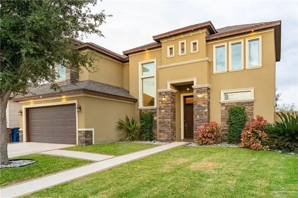front view of a house with a yard and an trees