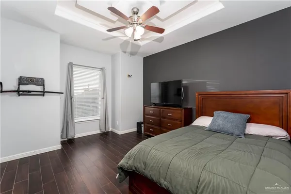a bedroom with a bed and a flat tv screen on dresser