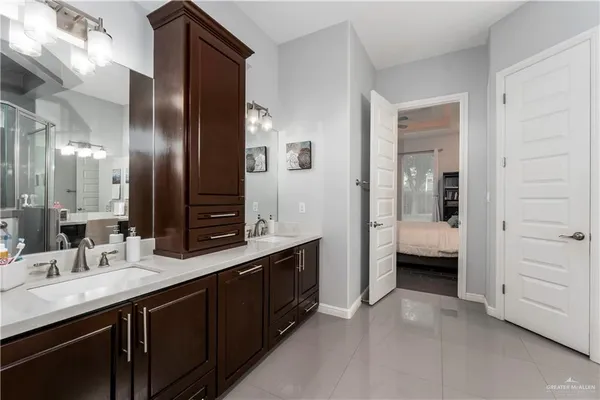 a en suite bathroom with a double vanity sink a large mirror and a shower