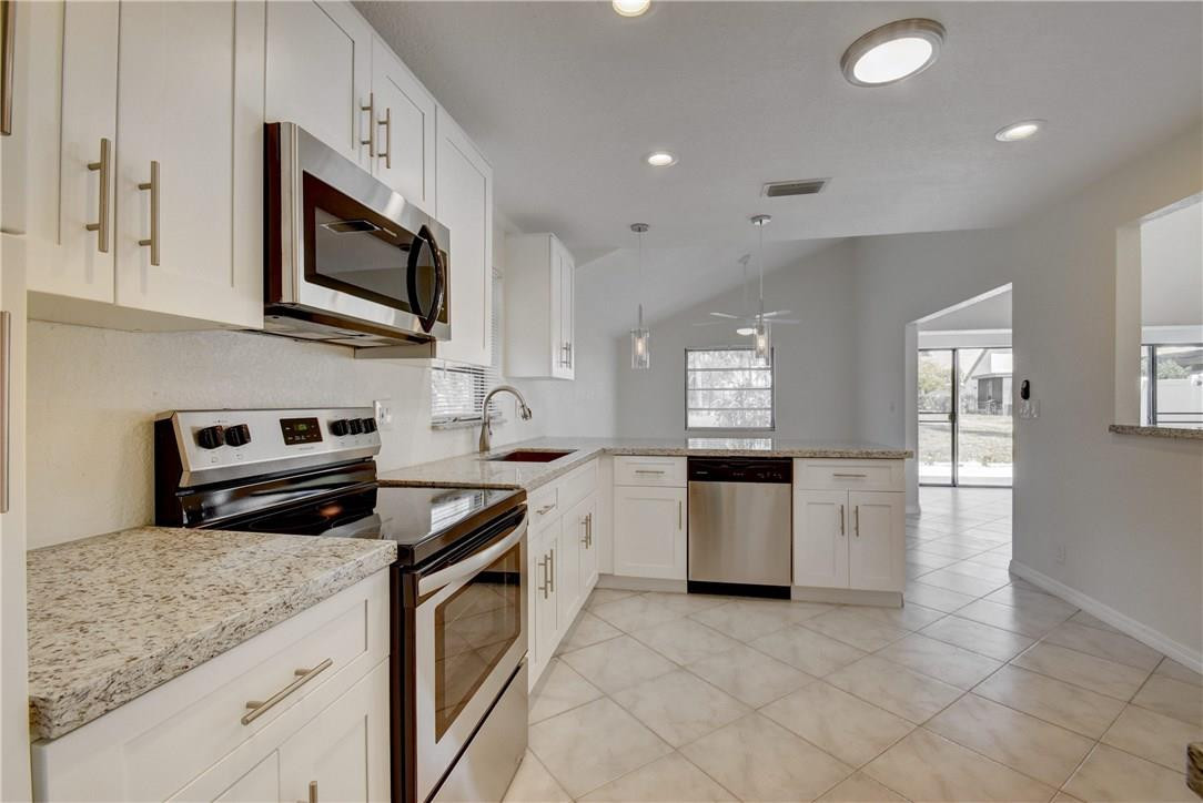 149 Southwest 15th Drive Boca Raton, FL 33432 - Photo 10 of 28 a kitchen with a stove sink and microwave