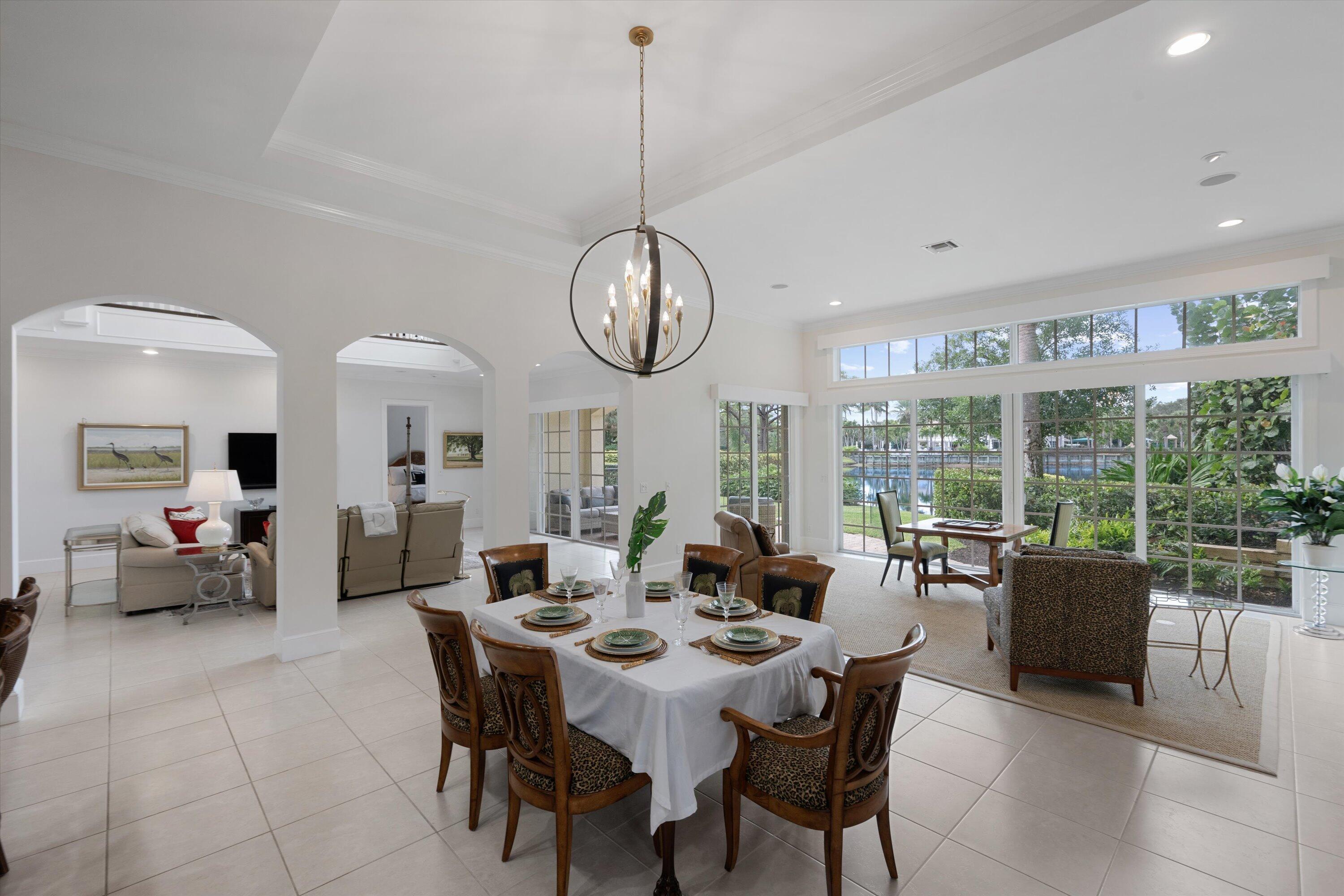 113 Caballo Lane Jupiter, FL 33458 - Photo 16 of 51 a view of a dining room with furniture large windows and a chandelier