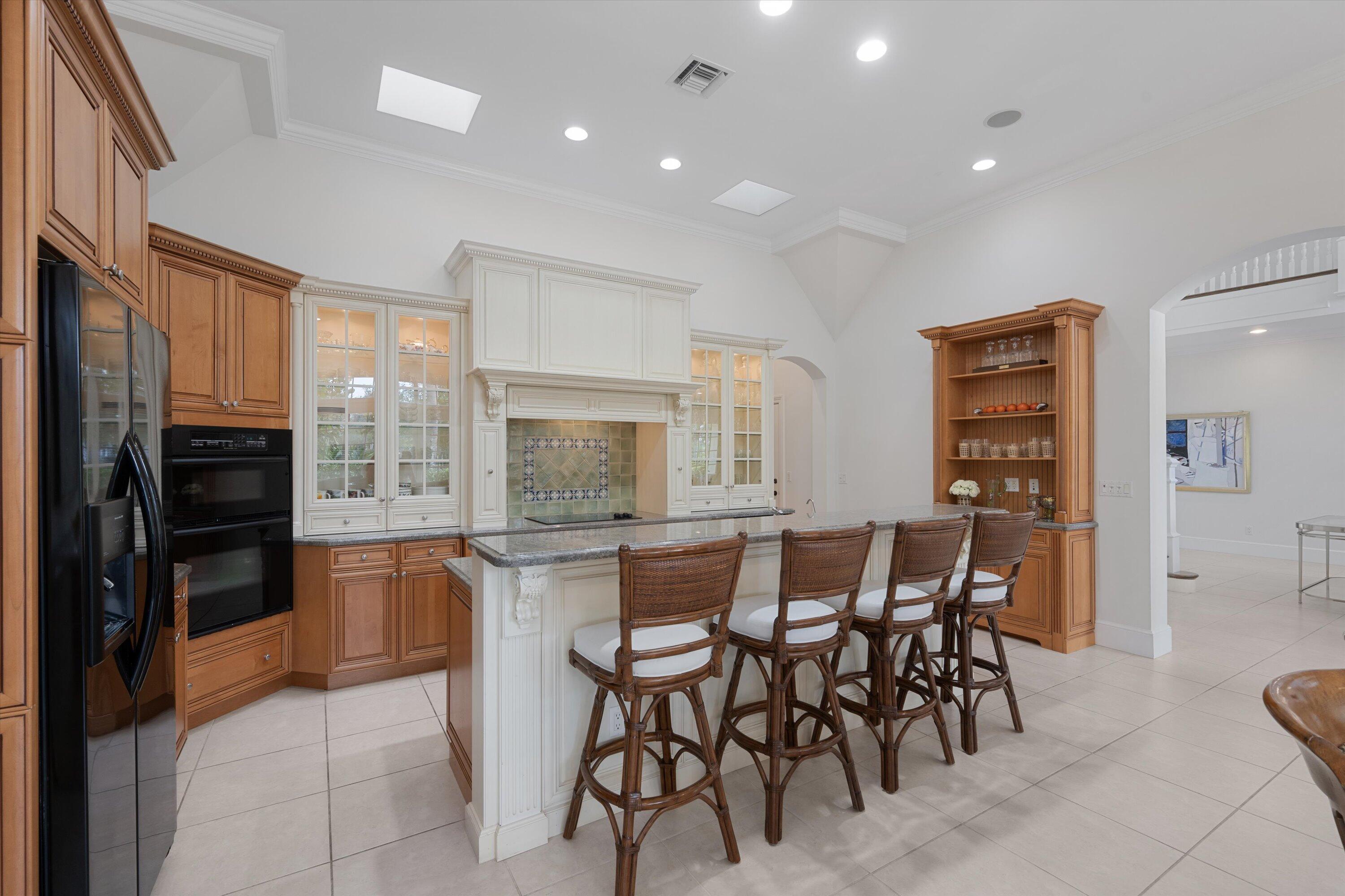113 Caballo Lane Jupiter, FL 33458 - Photo 19 of 51 a kitchen with stainless steel appliances kitchen island granite countertop a refrigerator and cabinets