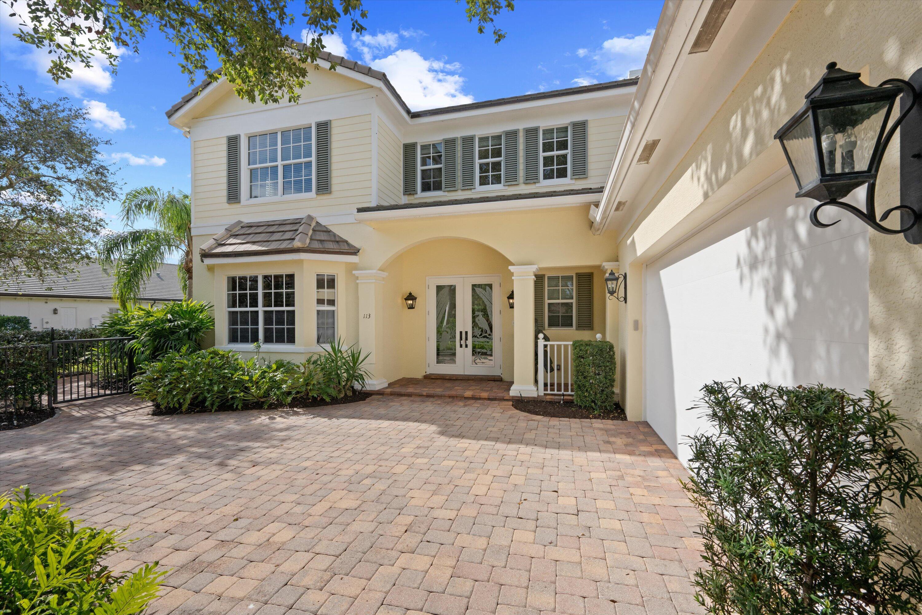 113 Caballo Lane Jupiter, FL 33458 - Photo 2 of 51 a front view of a house with garden