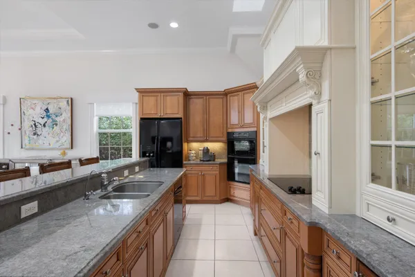 a large kitchen with granite countertop a large counter top space appliances and a window