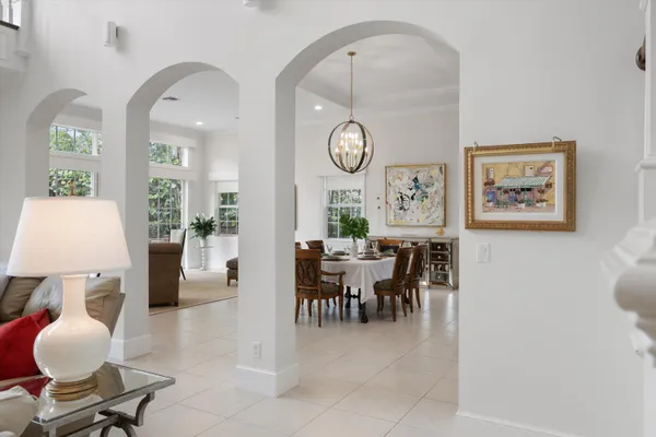 a living room with furniture and a large mirror next to a window