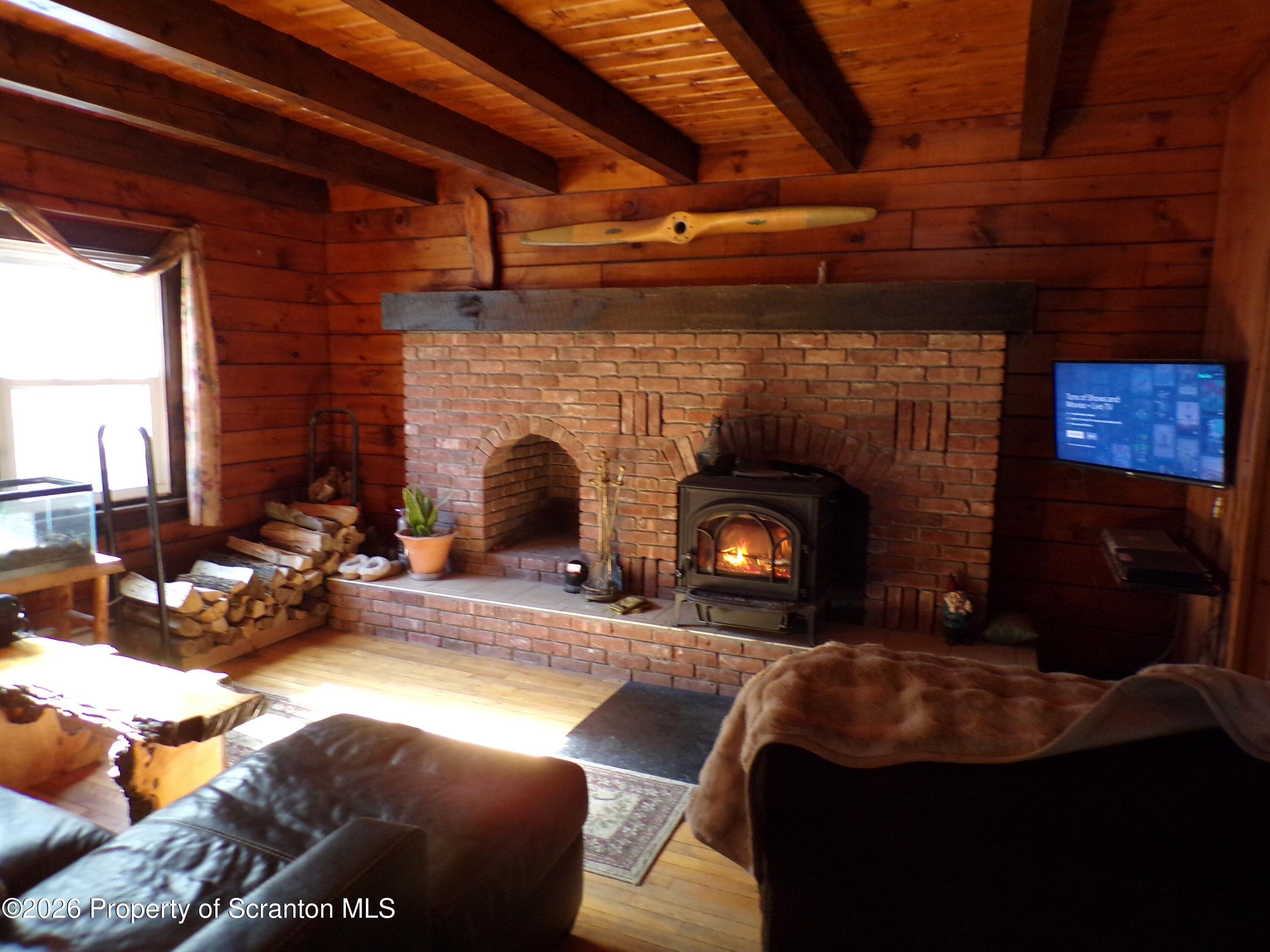 2590 Potter Hill Road Thompson, PA 18465 - Photo 20 of 43 a living room with furniture and a fireplace