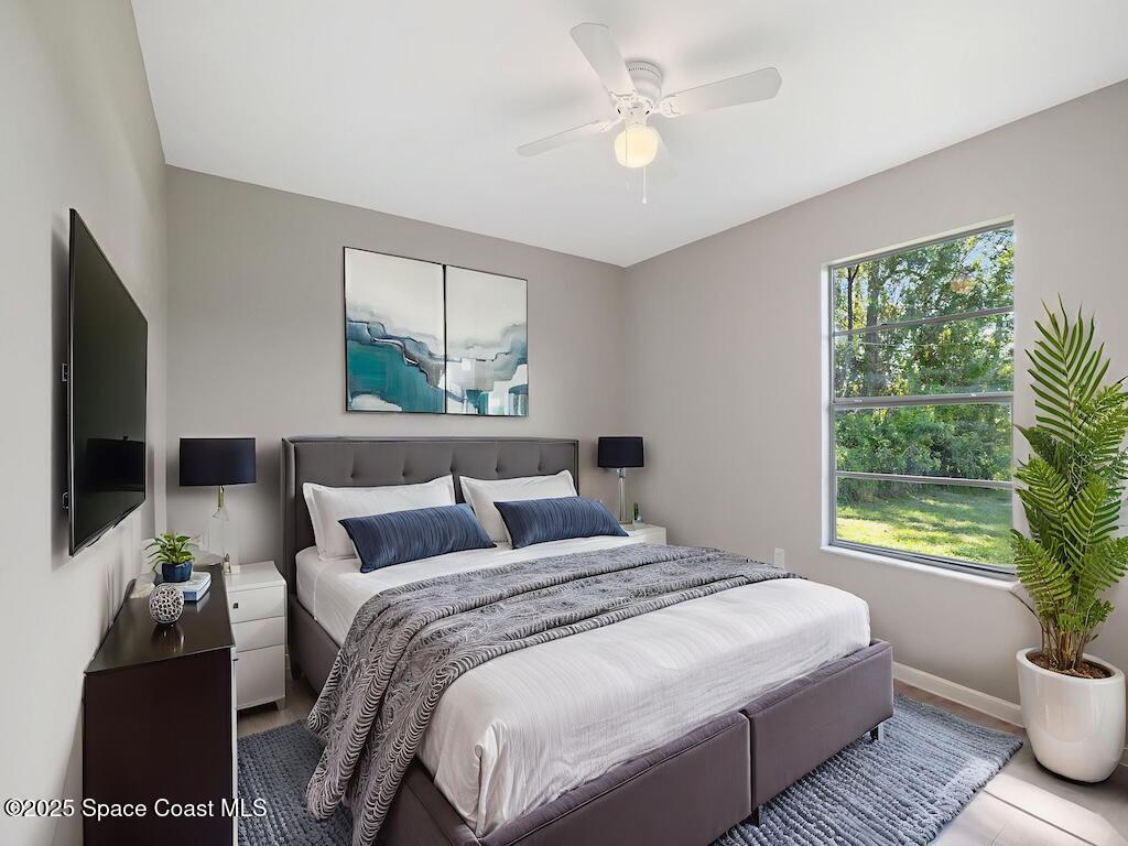 274 Trilby Road Southwest Palm Bay, FL 32908 - Photo 14 of 38 a bedroom with a large bed and a window