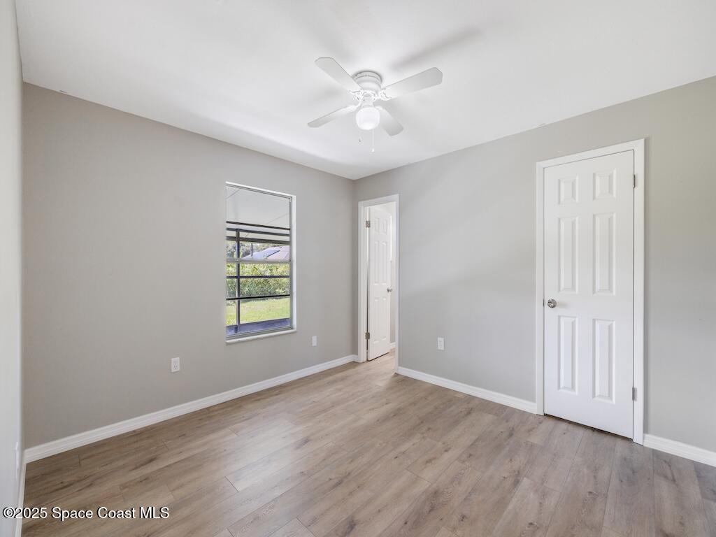 274 Trilby Road Southwest Palm Bay, FL 32908 - Photo 19 of 38 an empty room with wooden floor and window