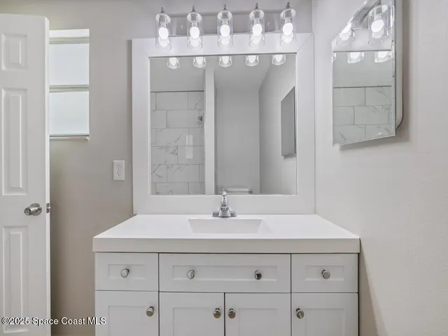 a bathroom with a sink vanity and a mirror