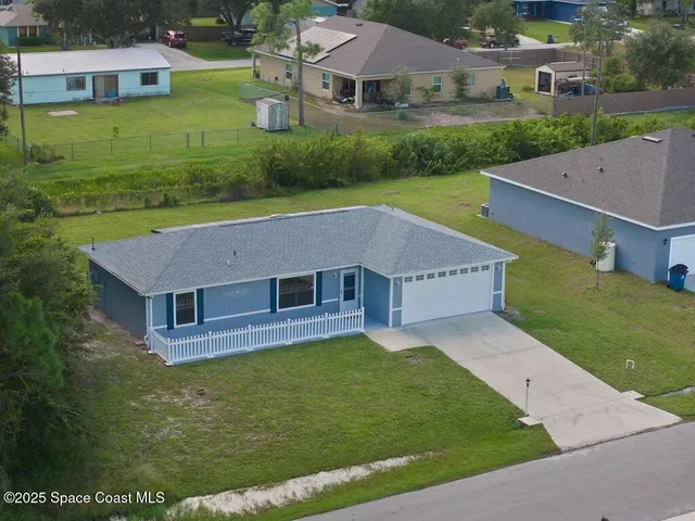 a aerial view of a house with a yard table and chairs