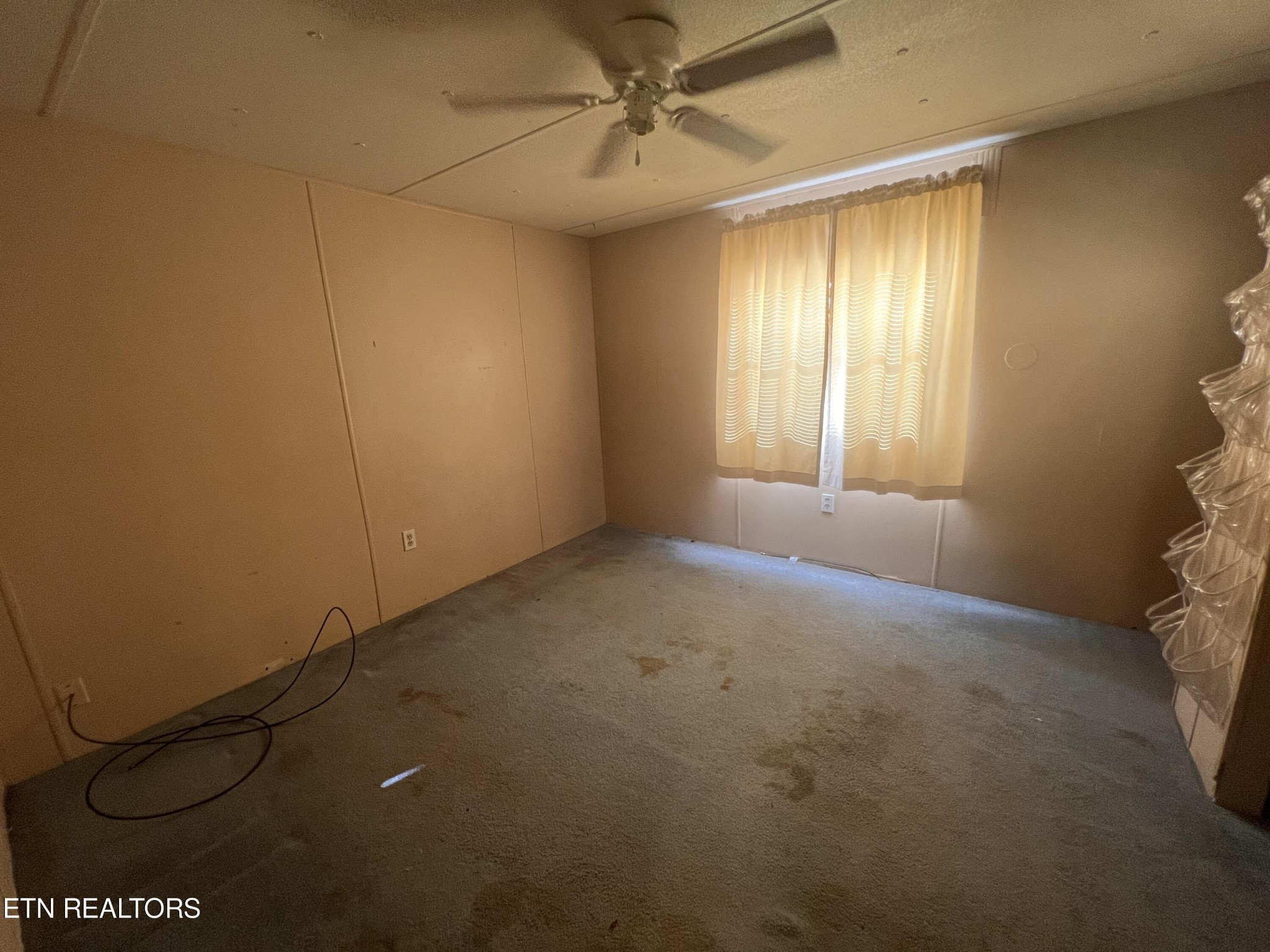 372 Longmire Road Clinton, TN 37716 - Photo 6 of 7 an empty room with windows and fan