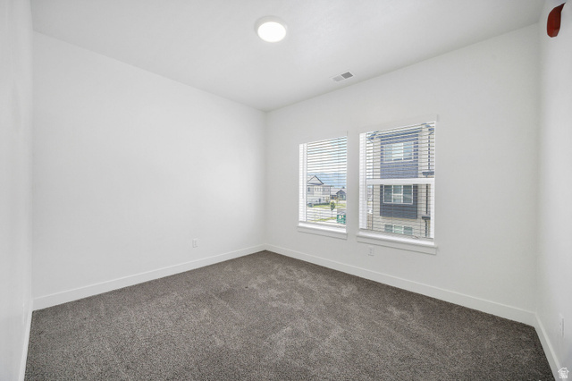 3115 South 200 West, Unit C201 Nibley, UT 84321 - Photo 14 of 23 Carpeted room featuring white walls, white baseboards, two windows with blinds, and an overhead recessed light fixture