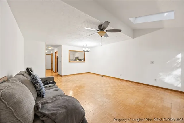 a living room with a bed furniture and a ceiling fan