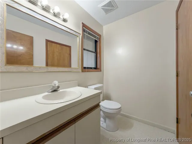 a bathroom with a sink a toilet and mirror