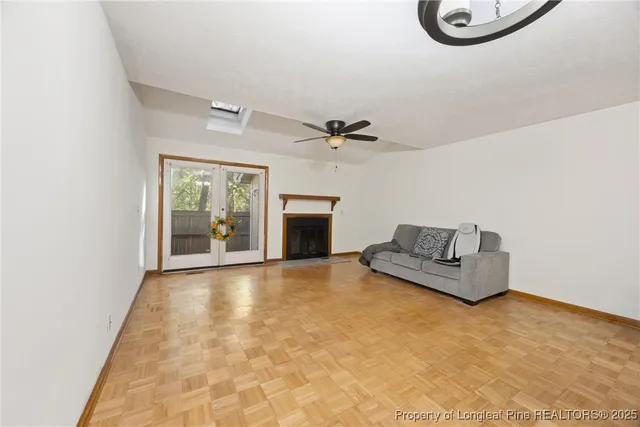 an empty room with windows and fireplace