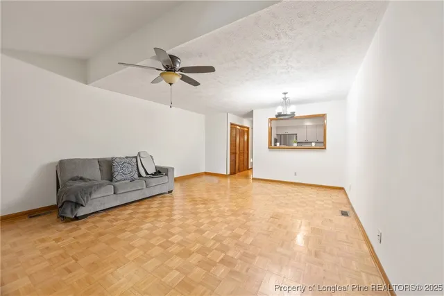 a living room with furniture and a ceiling fan