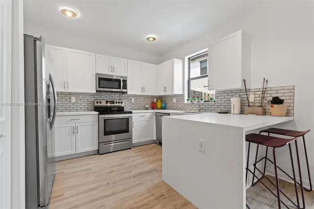a kitchen with cabinets appliances and a sink