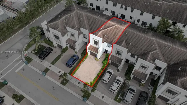 an aerial view of residential houses with outdoor space and parking