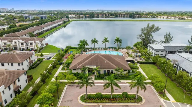 a room with stainless steel appliances kitchen island granite countertop a refrigerator and a sink