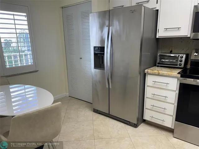 a kitchen with stainless steel appliances granite countertop a refrigerator and a stove