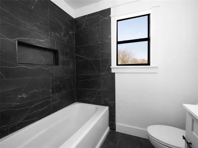 a bathroom with a bathtub and a toilet