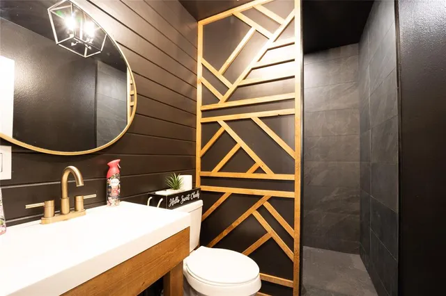 a bathroom with a sink vanity mirror and toilet