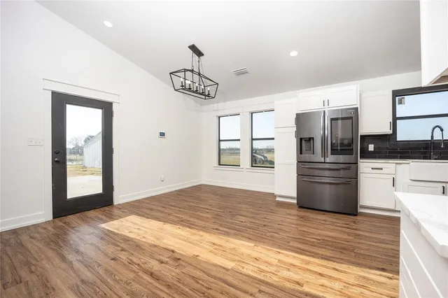 a kitchen with stainless steel appliances kitchen island granite countertop a refrigerator and cabinets