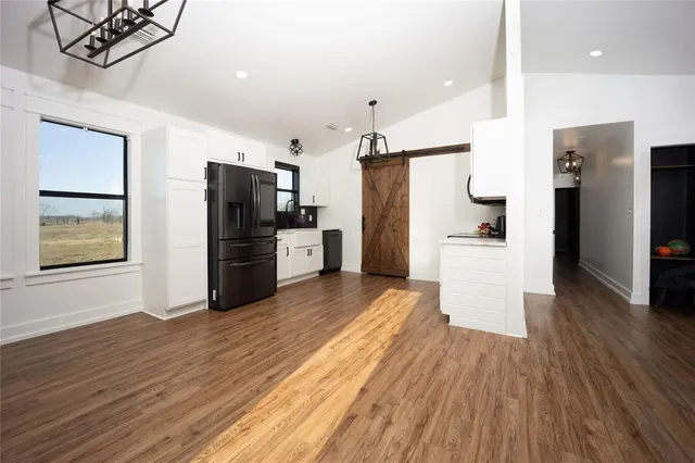 a kitchen with stainless steel appliances a refrigerator and wooden floor