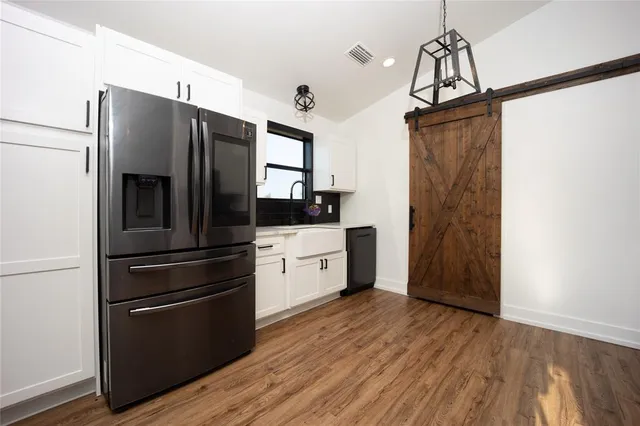 a kitchen with stainless steel appliances a refrigerator and wooden floor