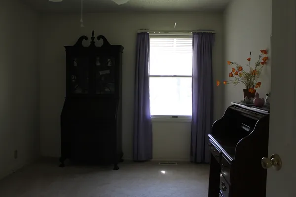 a view of a chandelier fan and window in an empty room