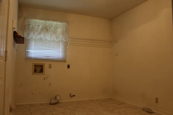 a view of a small space with wooden door and a window