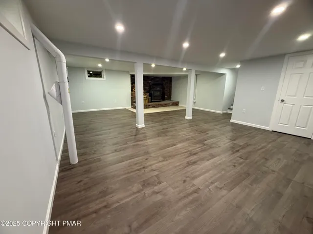 an empty room with wooden floor and staircase