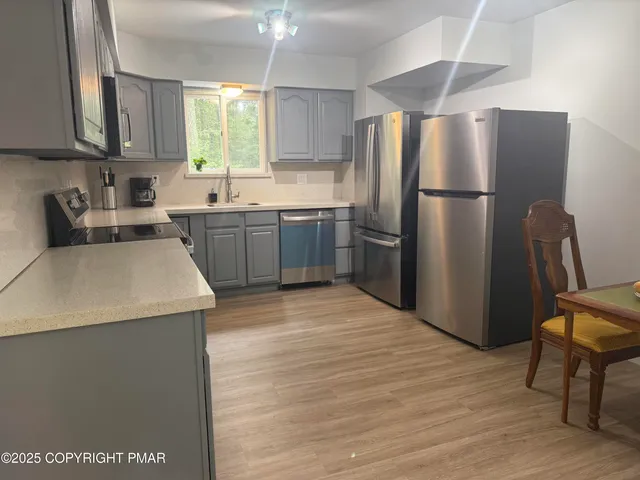 a kitchen with a refrigerator sink and cabinets