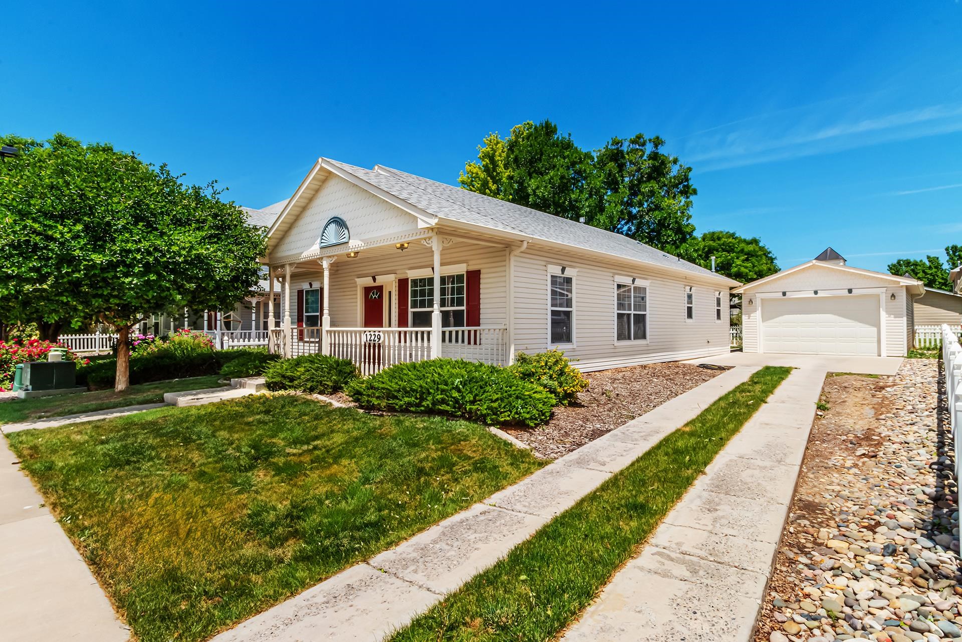 1229 Windsor Park Drive Fruita, CO 81521 - Photo 3 of 36 a view of a white house with a yard and potted plants