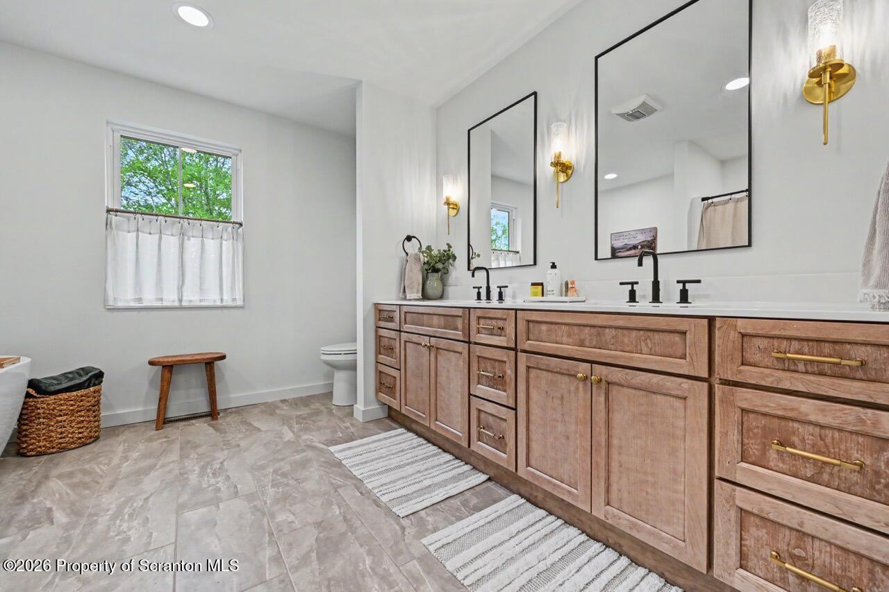 100 Highland Road Moscow, PA 18444 - Photo 50 of 85 a bathroom with double vanity sink a two mirror and a bathtub