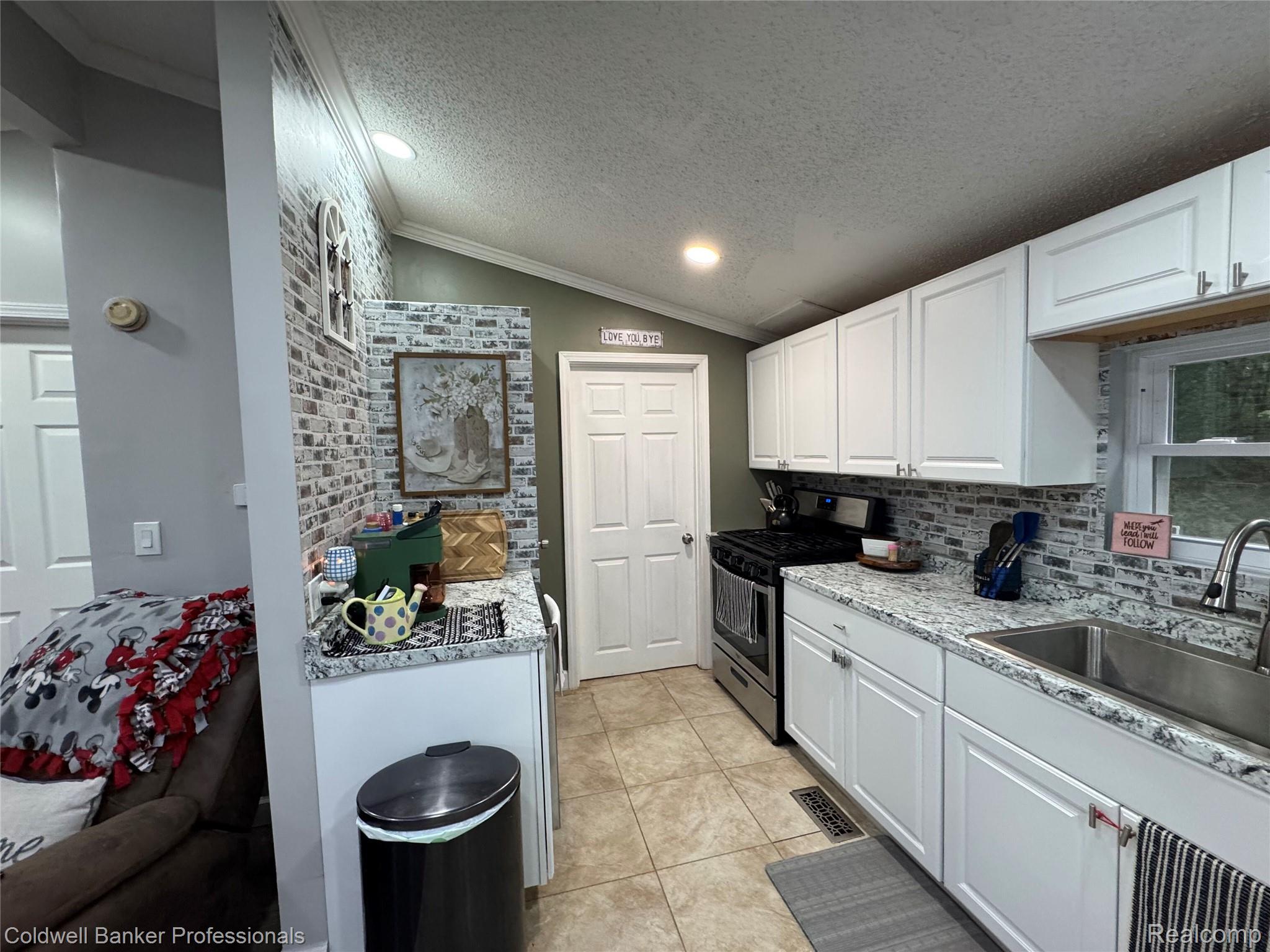 5323 English Road Clifford, MI 48727 - Photo 20 of 46 White cabinetry with brushed nickel hardware, granite-look countertops, subway tile backsplash, and stainless steel appliances