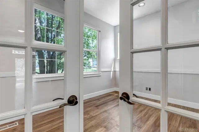 an empty room with wooden floor and windows