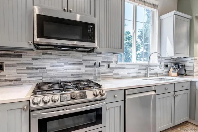 a view of a kitchen with fridge and wooden floor