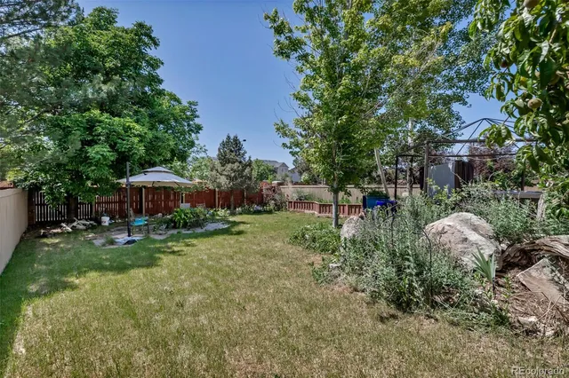 a view of backyard with table and chairs under an umbrella