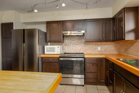 a kitchen with stainless steel appliances a sink and a refrigerator