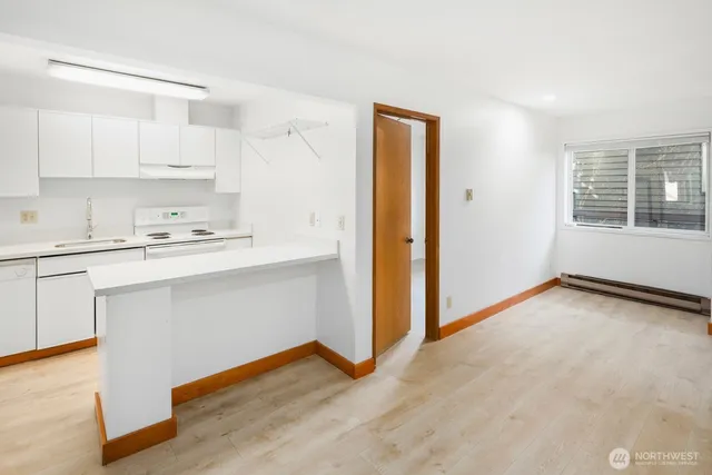 a kitchen with a sink cabinets stainless steel appliances and a window