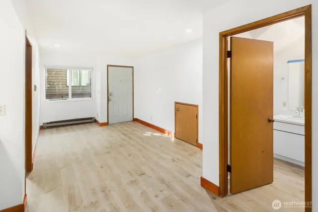 an empty room with wooden floor and a bathroom
