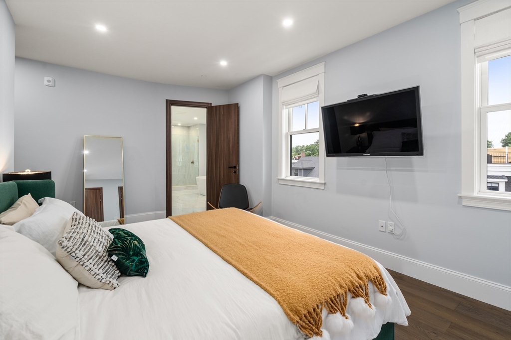 32 Pearl Street, Unit 4 Boston, MA 02125 - Photo 21 of 35 a bedroom with a large bed and a flat screen tv